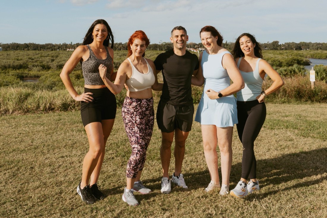 Andreas and a group of women smiling together outdoors under a big sky
